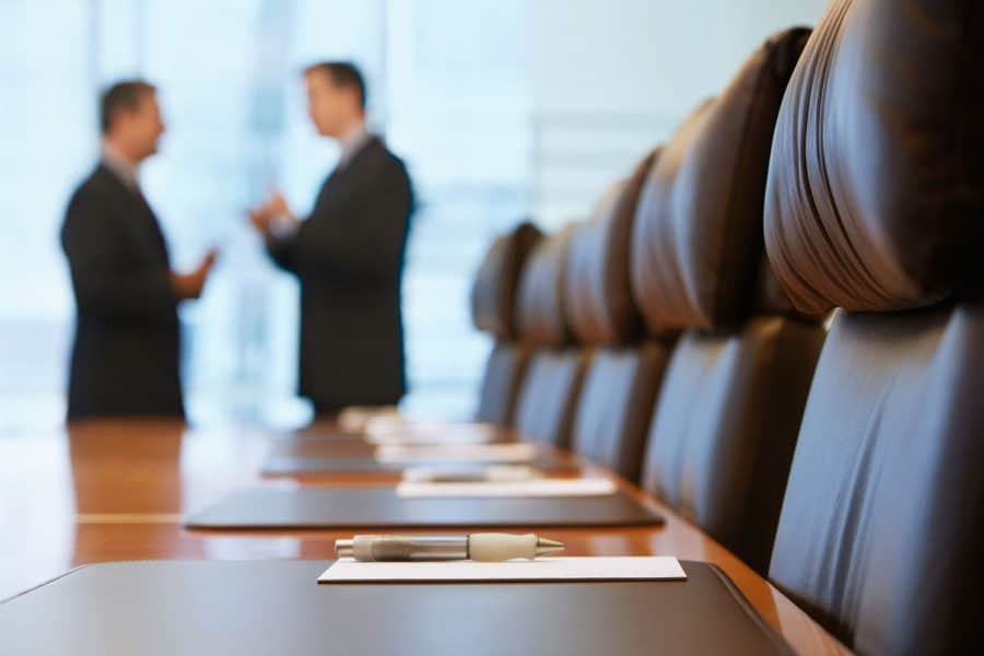 Legal Support for Industrial Hygiene Services - Blurred image of two men in a law office having a conversation. Brown chairs are in the foreground.