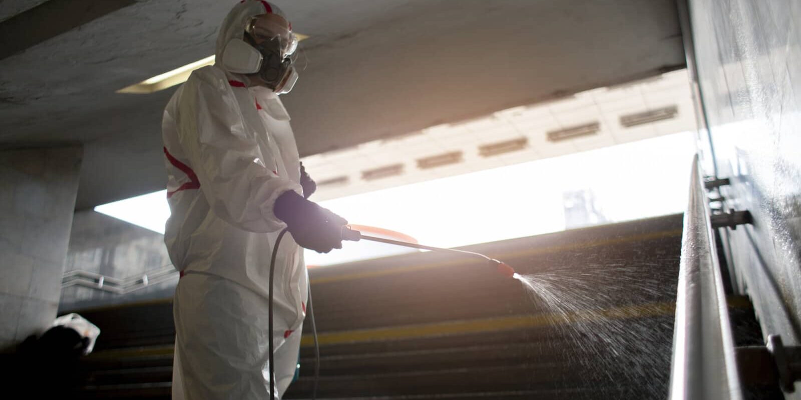 Occupational Exposure Limits (OELs) man inside a hazmat suite spraying, disinfectant Occupational Exposure Limits (OELs) man inside a hazmat suite spraying, disinfectant